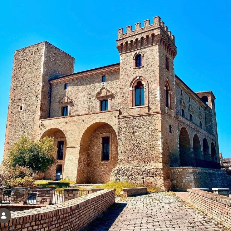 Medieval Ducal Castle in Crecchio, Abruzzo, Italy, with stone towers and arched portico under a clear blue sky