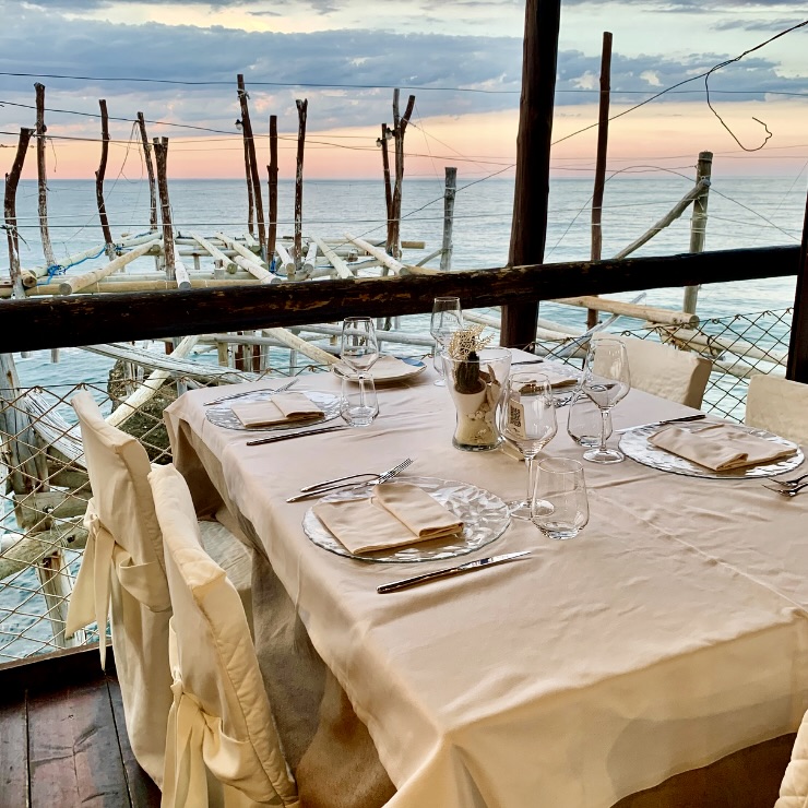 Dinner table set at sunset at Trabocco Punta Cavalluccio restaurant over the Adriatic Sea Abruzzo Italy
