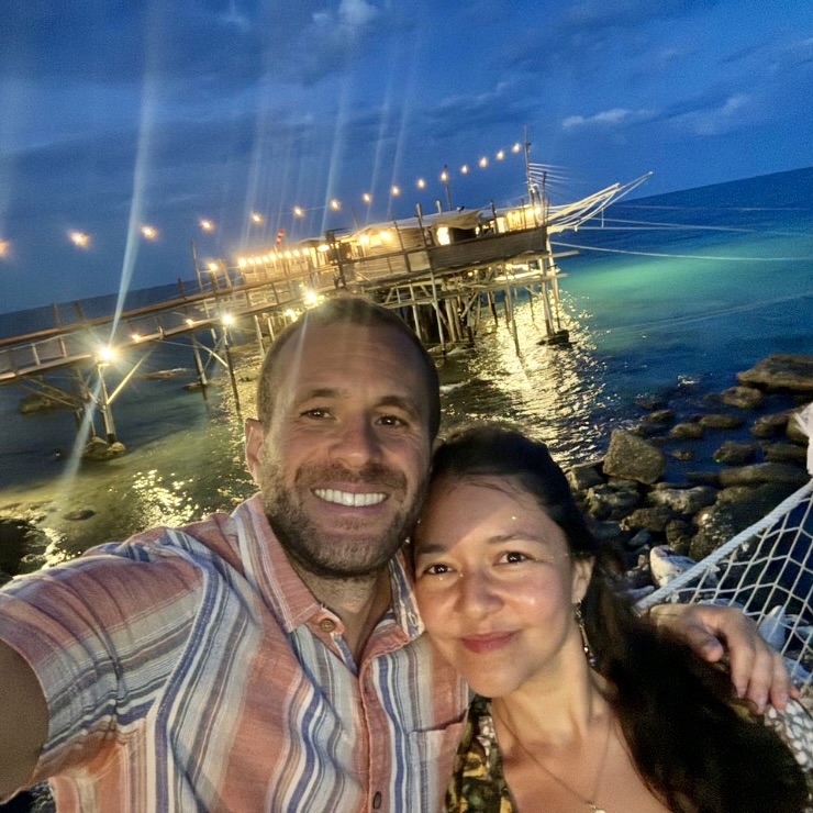 Couple at Trabocco Punta Cavalluccio illuminated at night over the Adriatic Sea Costa dei Trabocchi Abruzzo Italy