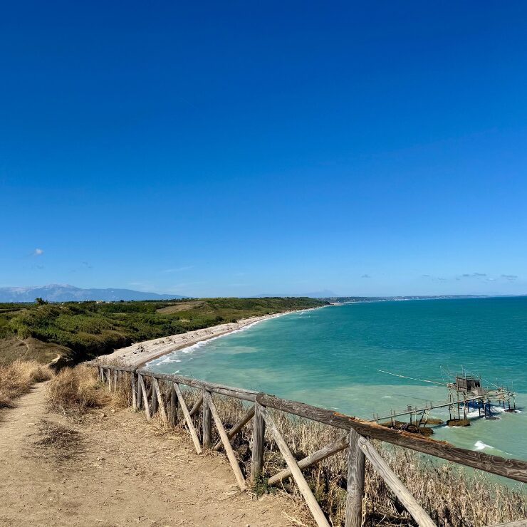 Coastal path at Punta Aderci nature reserve Abruzzo Italy with trabocco and La Maiella mountain in background