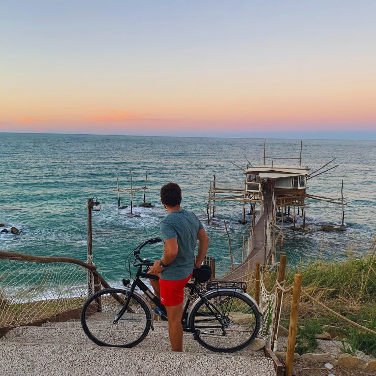 Cyclist at Trabocco Mucchiola sunset Costa dei Trabocchi cycling route Abruzzo Italy