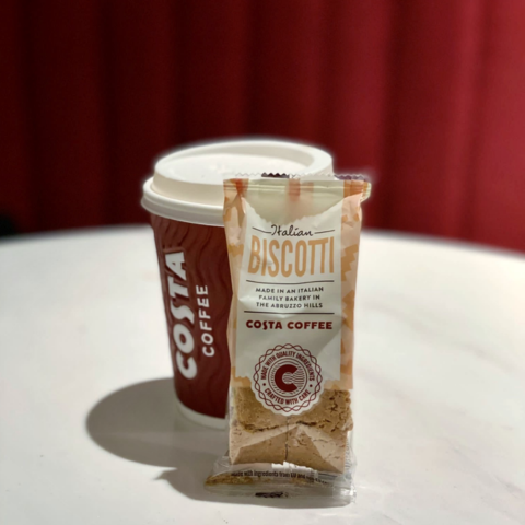A Costa Coffee cup next to a packet of Italian biscotti made in an Abruzzo family bakery